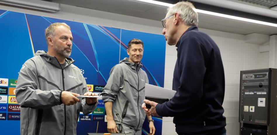 هانسي فليك يتحدث مع اللاعب البلجيكي السابق فرانكي فان دير إلست في نهاية المؤتمر الصحفي